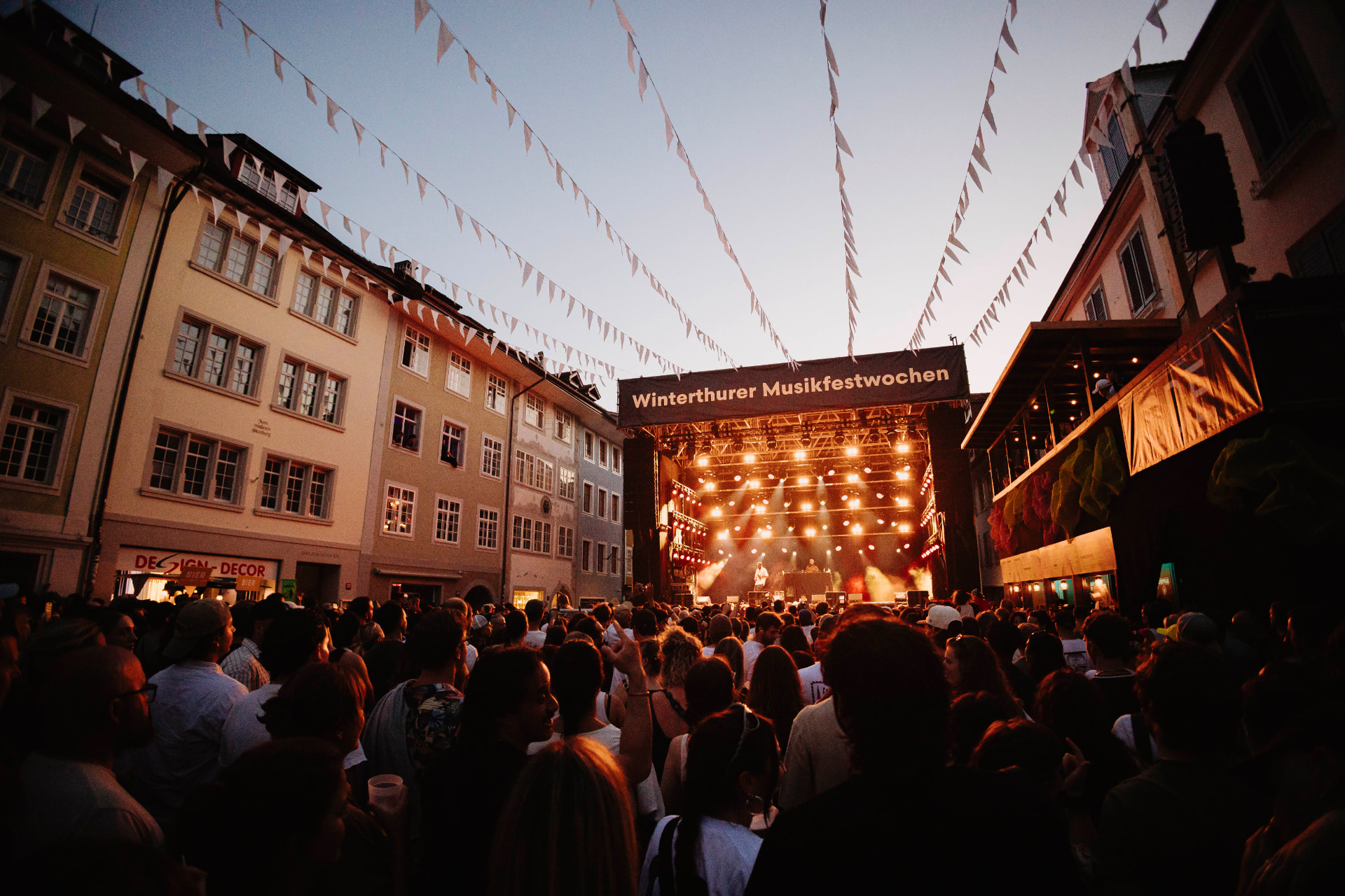 Festivalpublikum vor der Hauptbühne der Winterthurer Musikfestwochen in der Dämmerung
